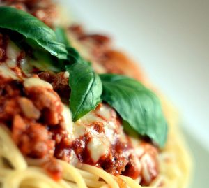 Ein Teller Spaghetti mit Bolognese-Sauce und frischem Basilikum, ideal für italienische Küche und Pasta-Liebhaber.