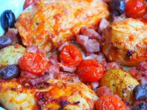 Gericht mit Hähnchenbrust, Kirschtomaten, Oliven und Speck, serviert in einer Pfanne, ideal für herzhafte Mahlzeiten.