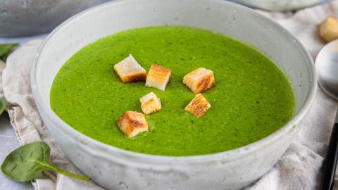 Eine Schüssel mit Spinat-Suppe, garniert mit knusprigen Croutons, ideal für gesunde Ernährung und vegetarische Rezepte.