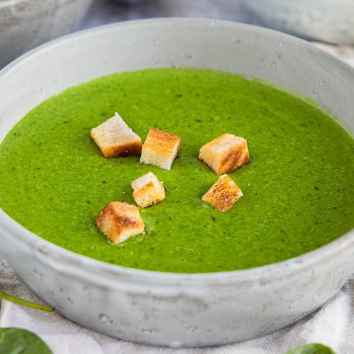 Eine Schüssel mit Spinat-Suppe, garniert mit knusprigen Croutons, ideal für gesunde Ernährung und vegetarische Rezepte.