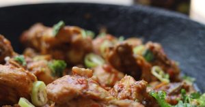 Leckeres Hähnchengericht mit frischem Gemüse und Kräutern in einer Pfanne, ideal für kulinarische Inspiration.