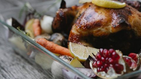 Geröstetes Hähnchen mit Zitrone und buntem Gemüse in einer Auflaufform, ideal für festliche Anlässe und Familienessen.