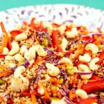 Bunter Quinoa-Salat mit frischem Gemüse, Cashewkernen und roten Paprika in einer dekorativen Schüssel.