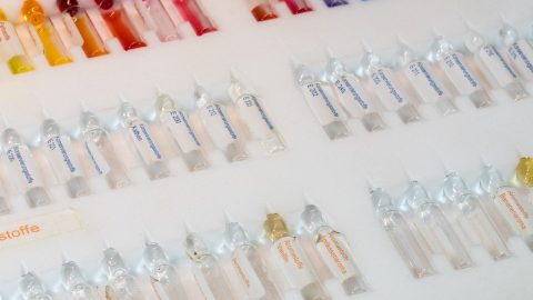 Eine Reihe von farbigen Ampullen mit verschiedenen Inhaltsstoffen, ideal für chemische Anwendungen und Produktentwicklung.