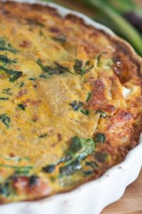 Leckere Gemüse-Quiche mit Spinat, Käse und einer goldbraunen Kruste, ideal für ein herzhaftes Gericht.