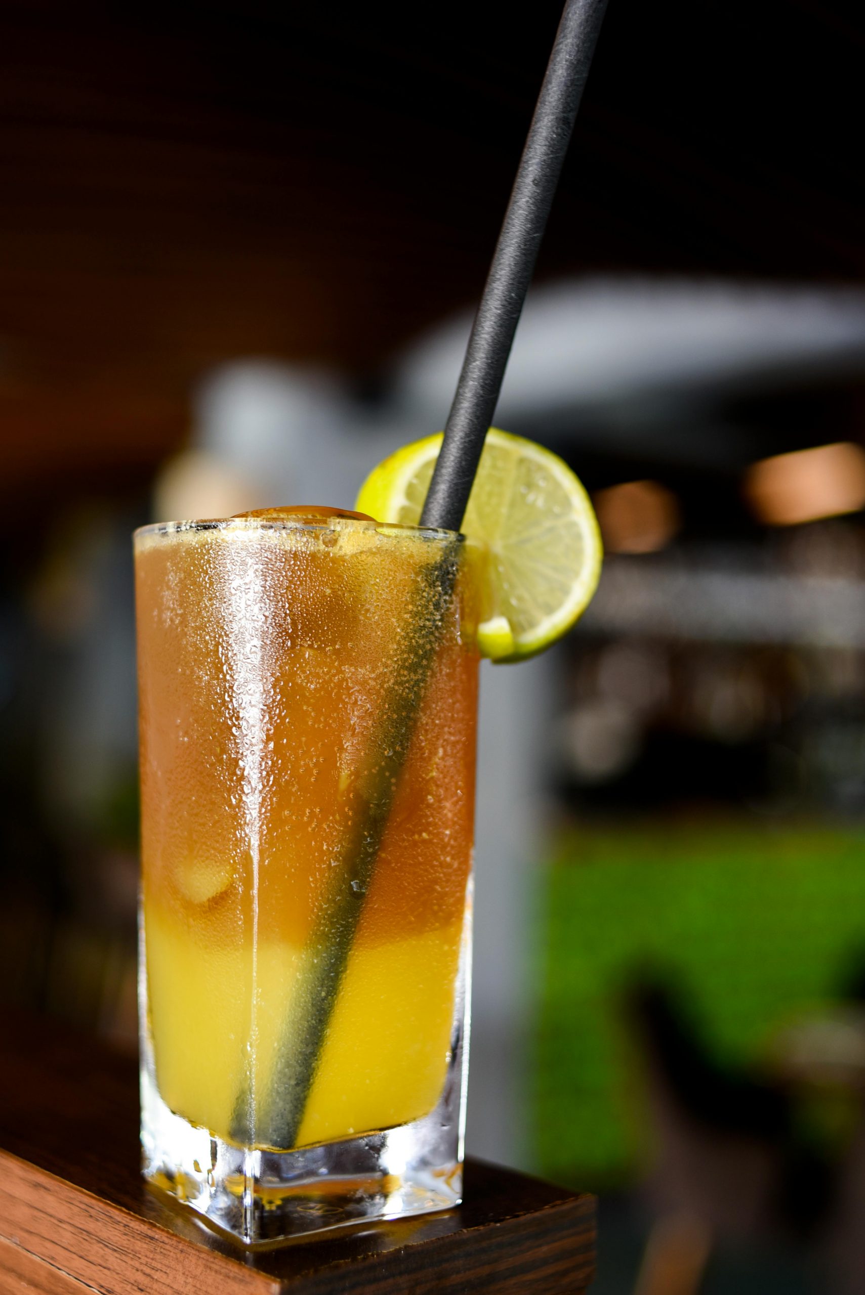 Clear Drinking Glass With Yellow Liquid and Black Straw