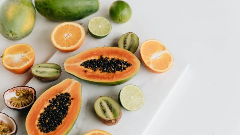 Geschnittene Limetten, Papaya, Beeren